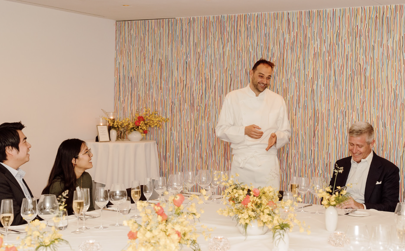 A group of smiling people seated at a set table.
