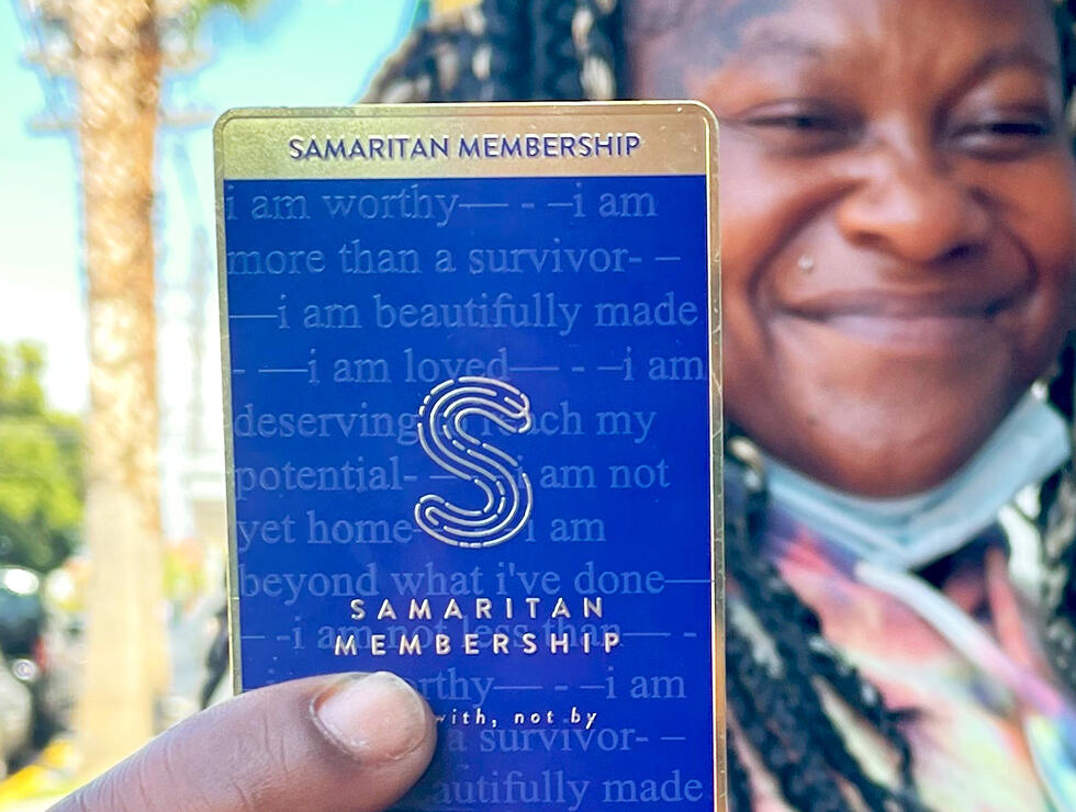 Women holds up a Samaritan membership card