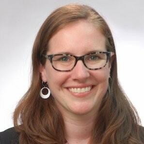 Image Description: Dr. Amy Hurst is looking directly into the camera, smiling. She is wearing brown glasses and circular earrings. Her hair is tucked behind her ears.