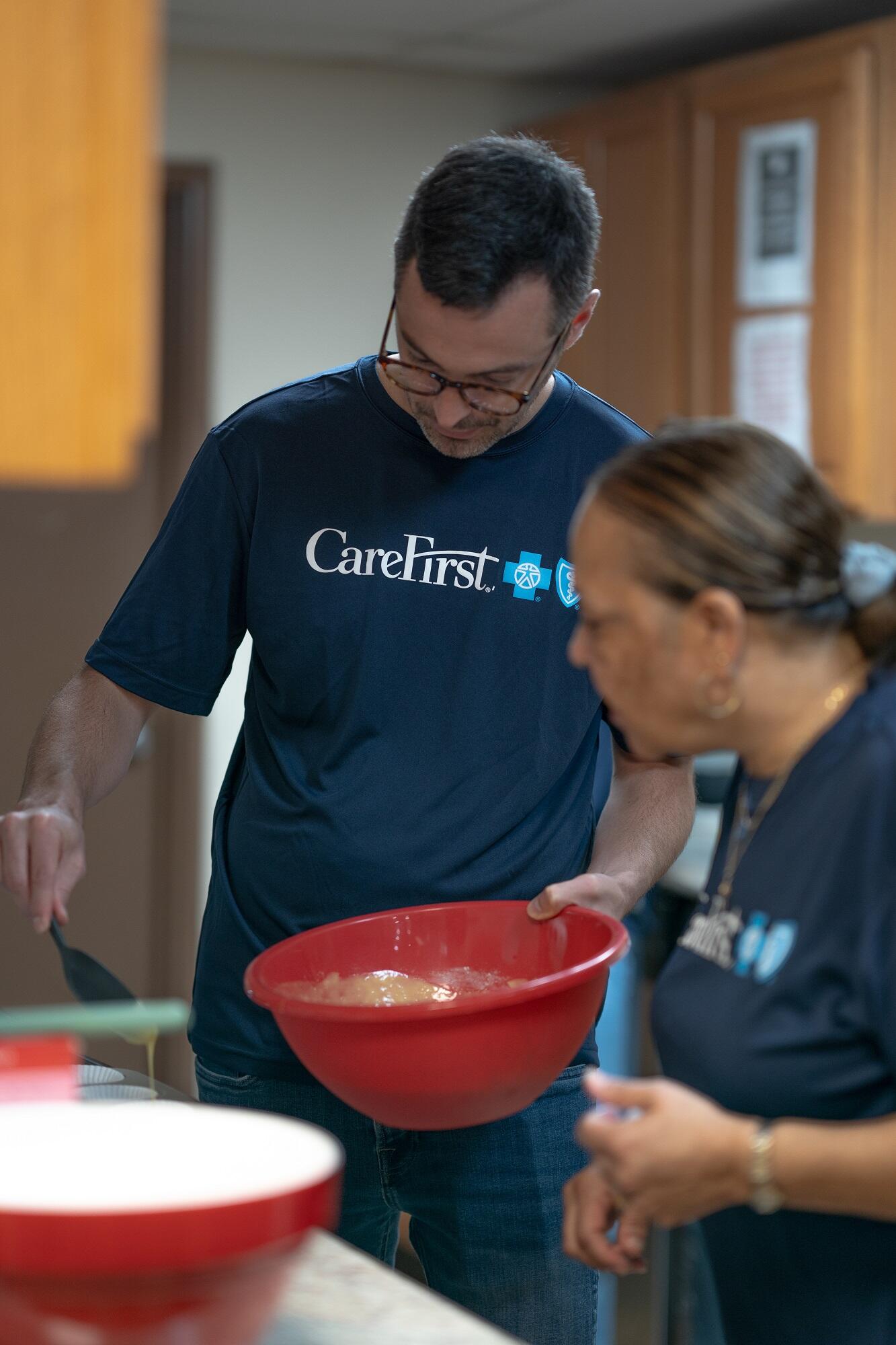 Employees making cupcakes for school children