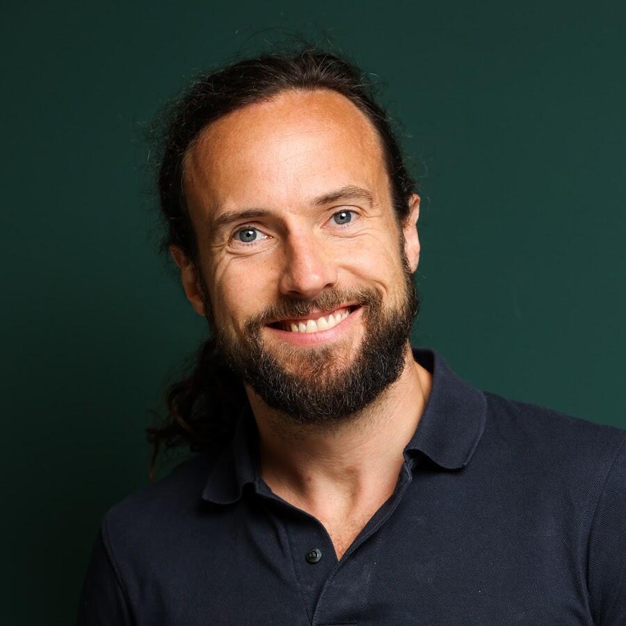 A middle-aged man with long brown hair in a ponytail and a beard