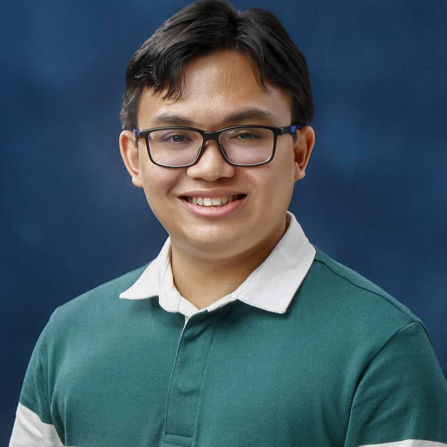 An Asian man wearing glasses and a green knit shirt with a white collar