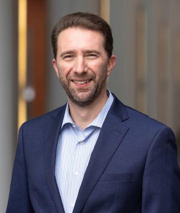 Smiling man with beard and blue jacket