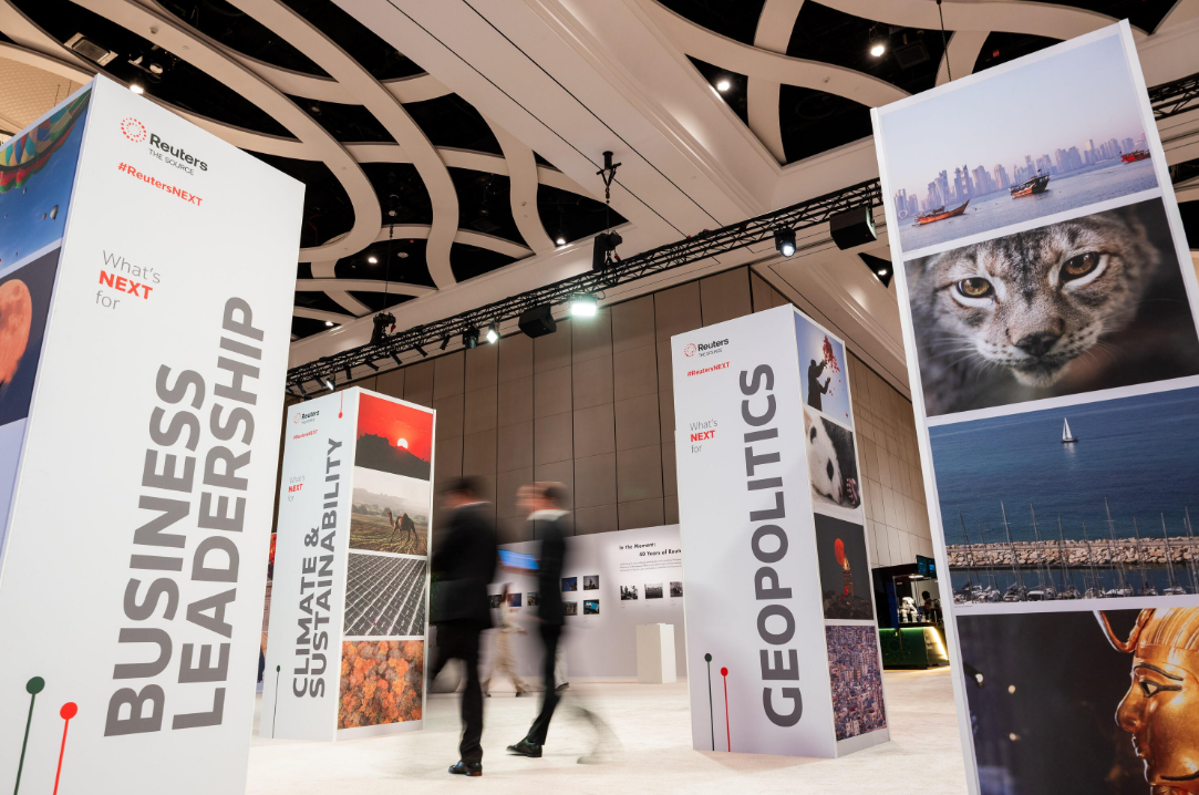 Reuters NEXT exhibition pillars display photography and event themes in a conference space.