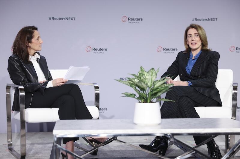 Onstage interview with two speakers seated at Reuters NEXT.