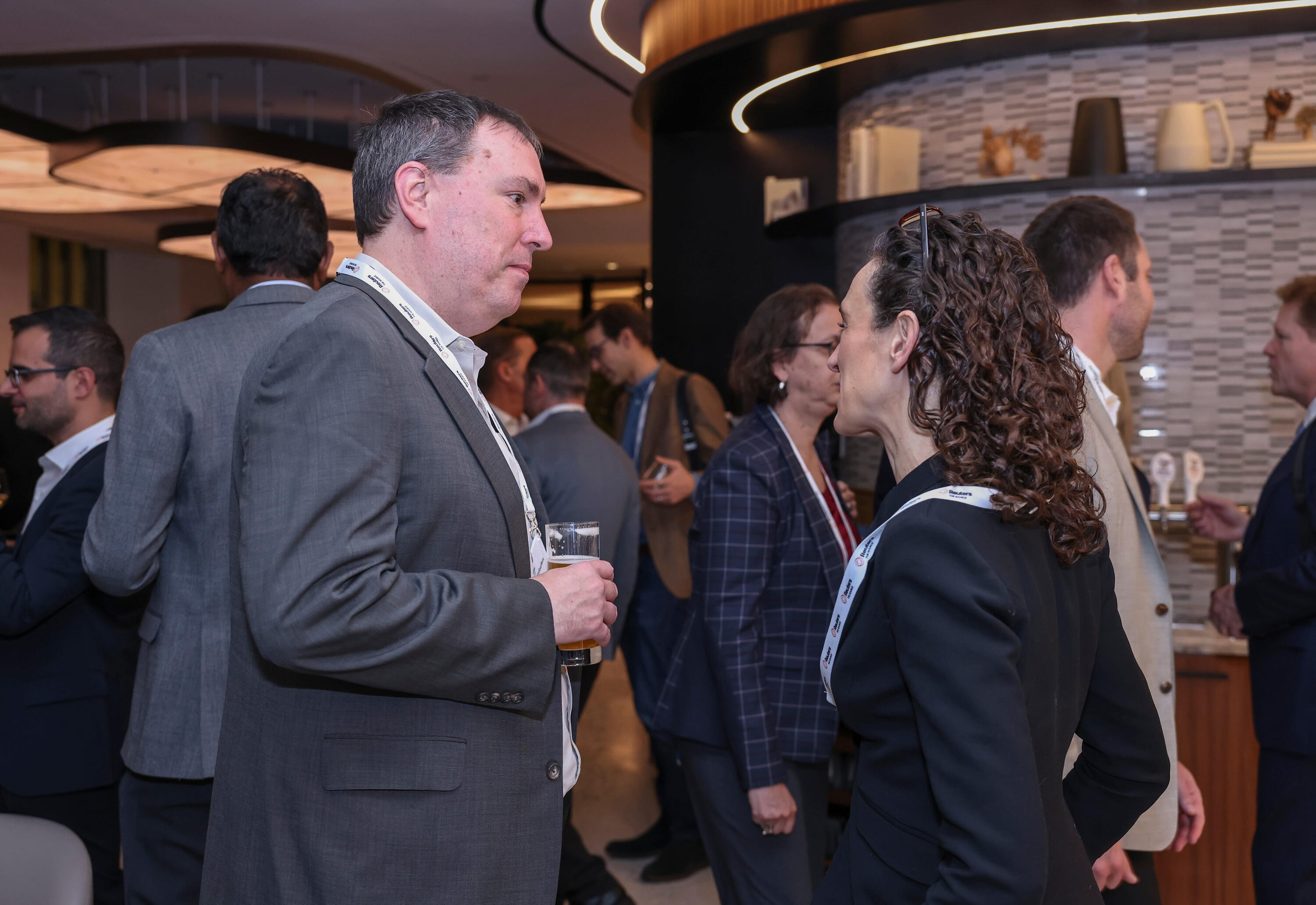 Two attendees networking over a drink at Reuters NEXT