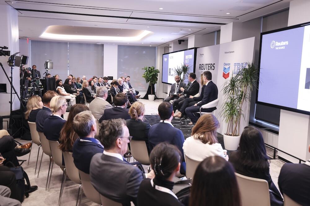Panel discussion with speakers on stage and audience seated at Reuters NEXT.
