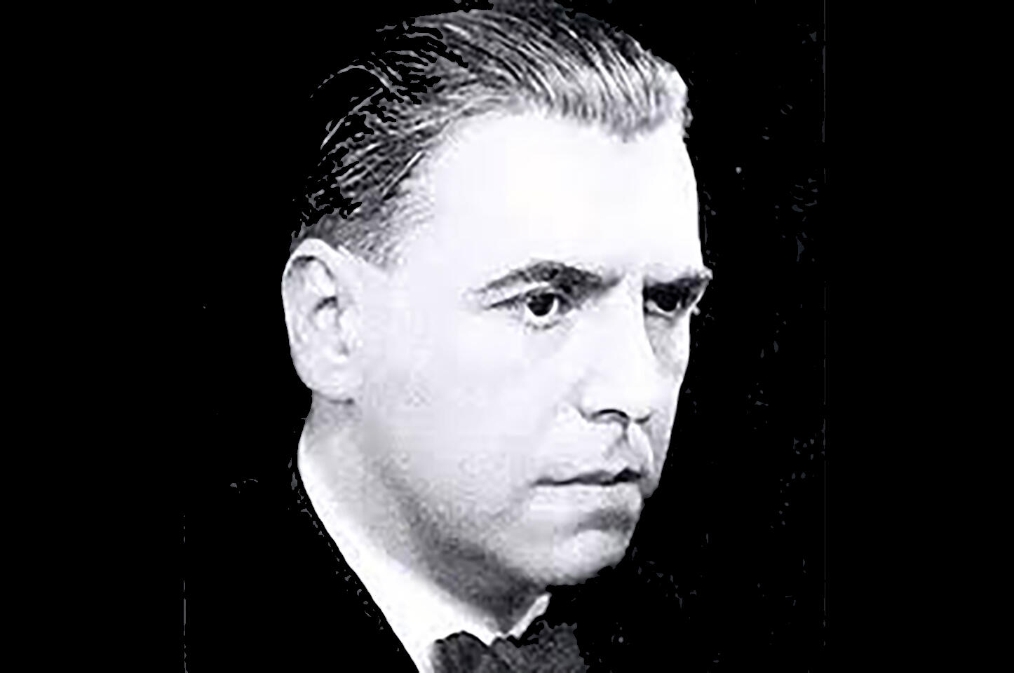 Black and white headshot of Ewrin Schulhoff a middle-aged white man with combed back short hair. He is not looing at viewer.