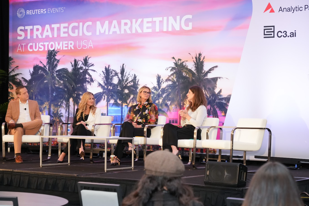 Four‑person panel conversing on stage beneath “Strategic Marketing” branding, emphasizing audience‑driven Q&A.