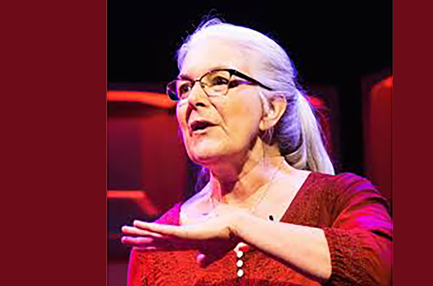 Photo of Tina Davidson, a white woman with a gram pony tail, and glasses, wearing a red top