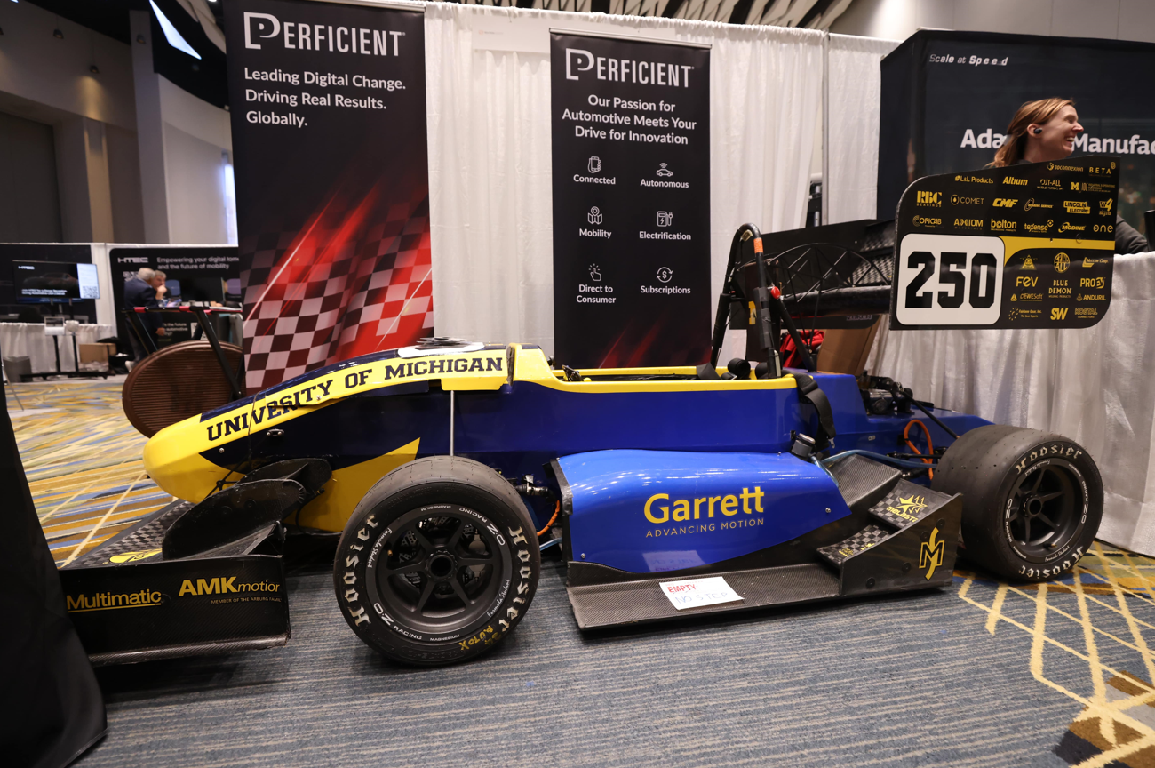 University of Michigan Formula SAE race car No. 250 at Reuters Events: Automotive USA, exhibited in front of Perficient’s booth with automotive innovation and electrification messaging and sponsor logos.