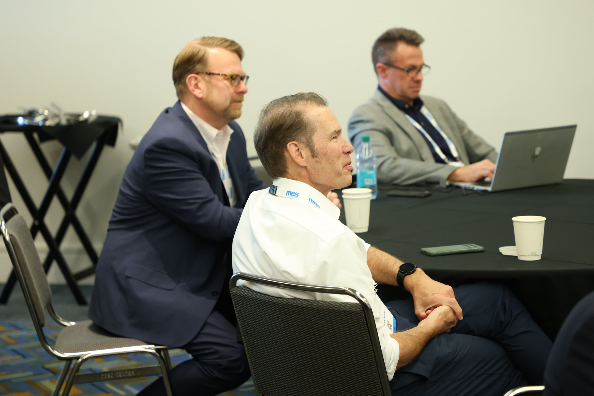 Automotive conference breakout at Reuters Events: Automotive USA, with industry professionals seated at a round table, taking notes and working on a laptop during the session.