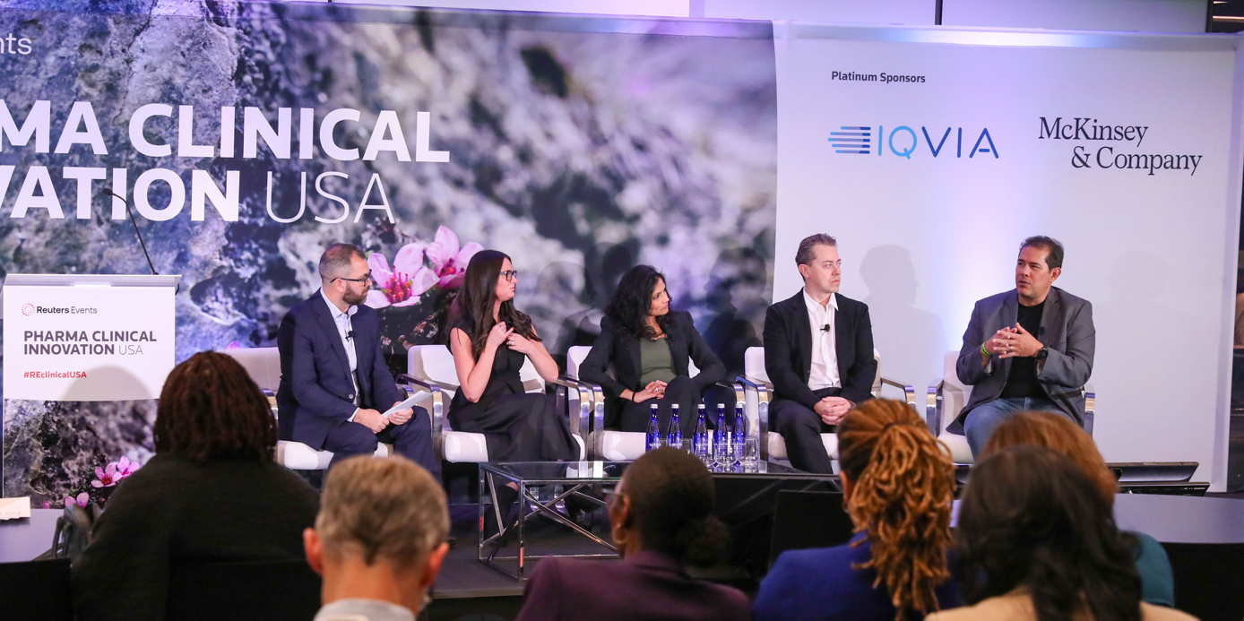 Five panellists seated on stage at a Reuters Events Pharma Clinical Innovation USA conference, with IQVIA and McKinsey & Company listed as Platinum Sponsors on a banner to the right.