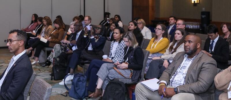 A photo of a group of people sitting listening to a presentation