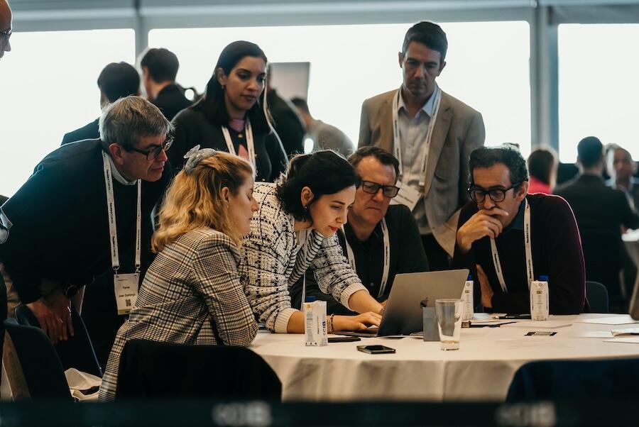A group around a laptop discussing a topic