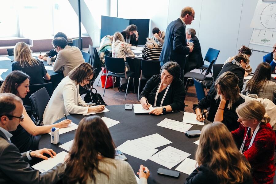 A roundtable taking place with a group pf people discussing a topic
