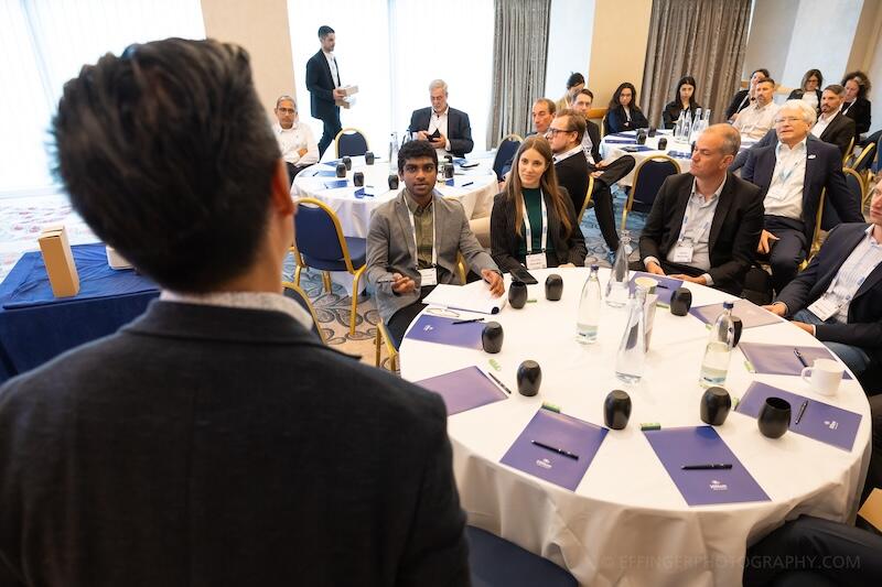 a Person talking to people sitting at tables.