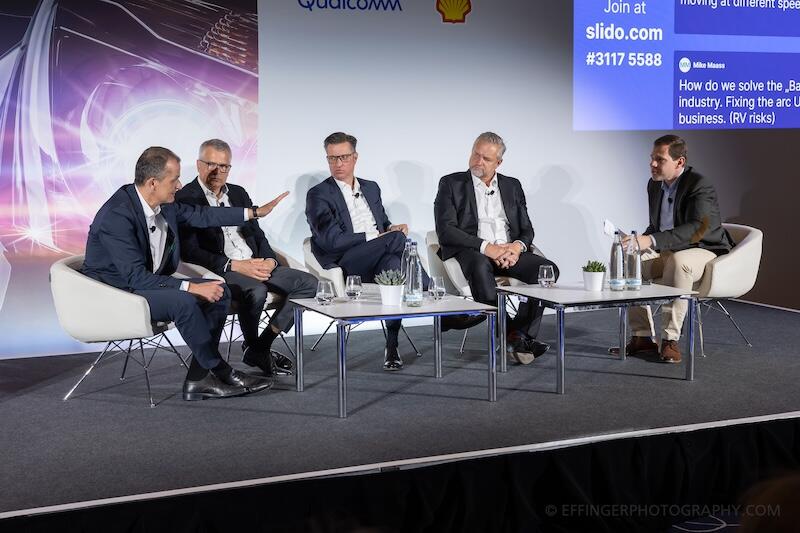 A panel of people oin stage discussing a topic.