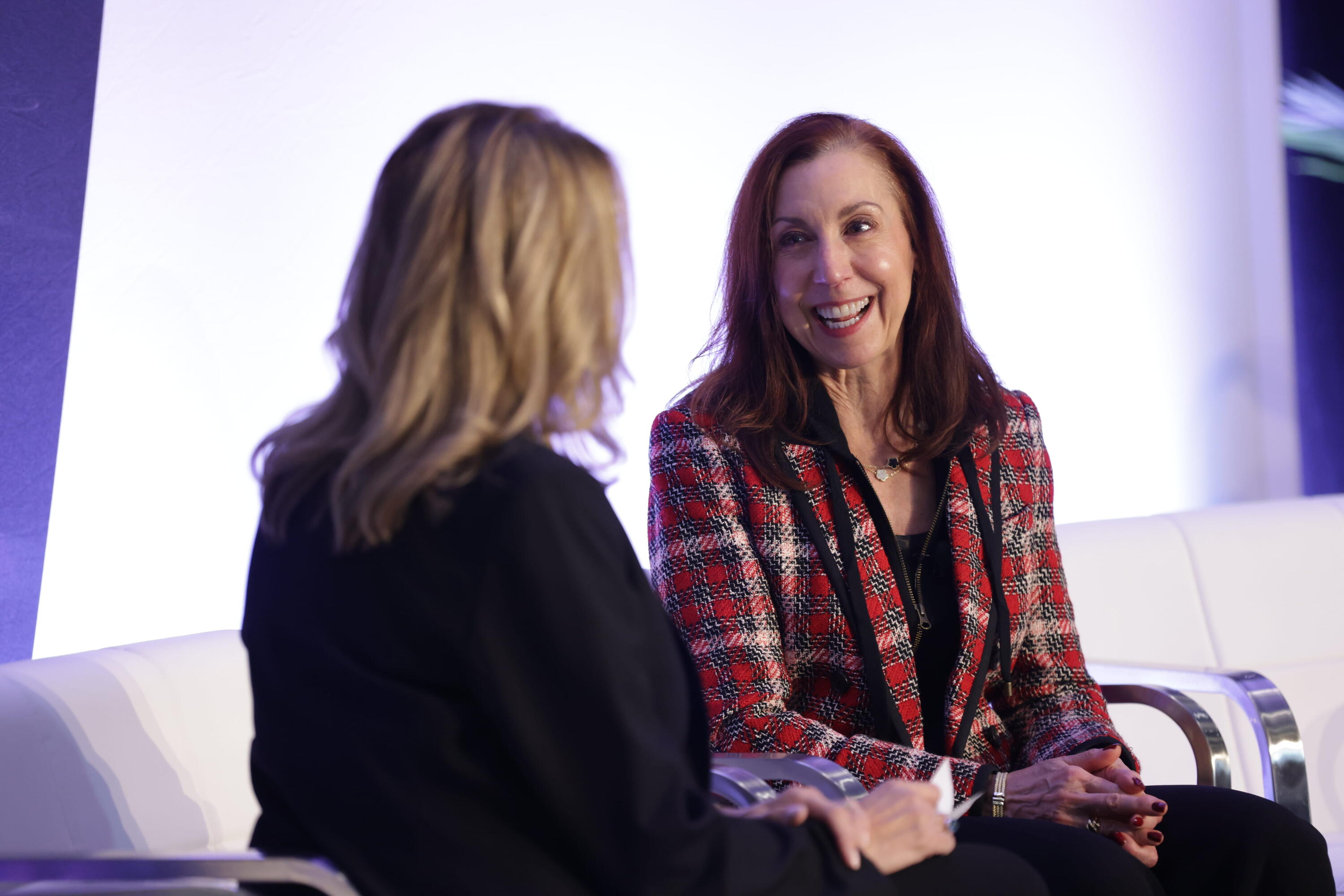 2 speakers onstage, mid conversation at an event