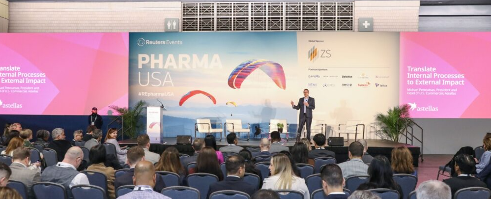 Keynote session at PHARMA USA; speaker addresses a full audience with slides reading "Translate Internal Processes to External Impact," sponsor ZS displayed.