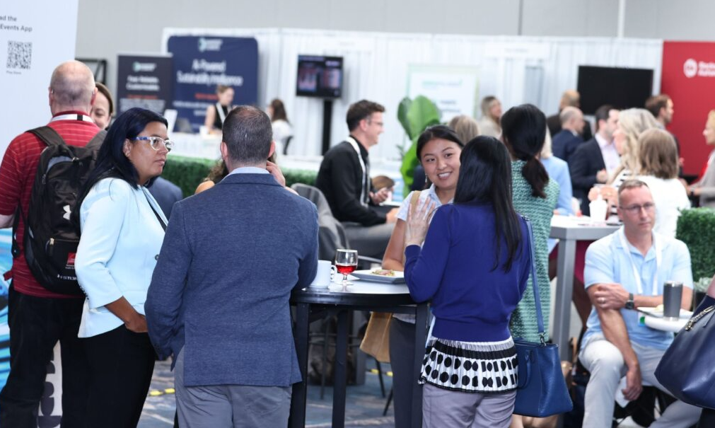 Attendees network around high-top tables in a busy expo lounge at the Responsible Business USA 2025 sustainability conference.
