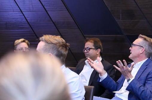 Seated attendees during an interactive session, one gesturing
