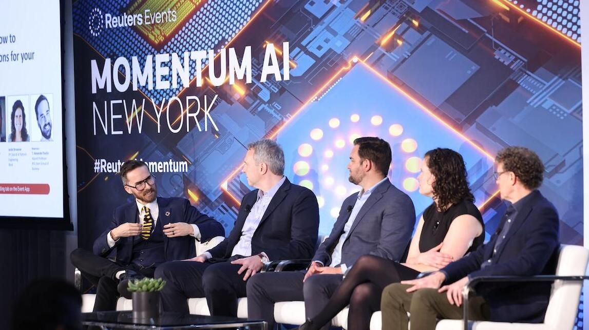 A photo of a gorup of 5 people on stage discussing a topic
