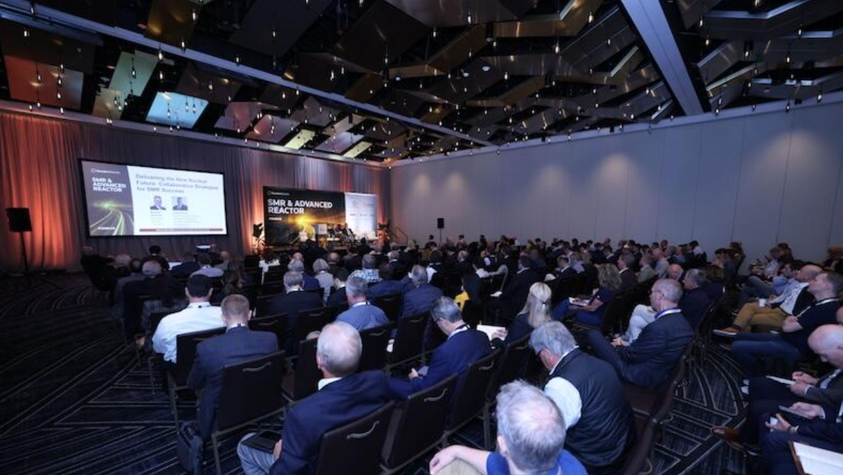 Audience fills ballroom for an SMR & Advanced Reactor panel, with stage lighting and branded screens visible.