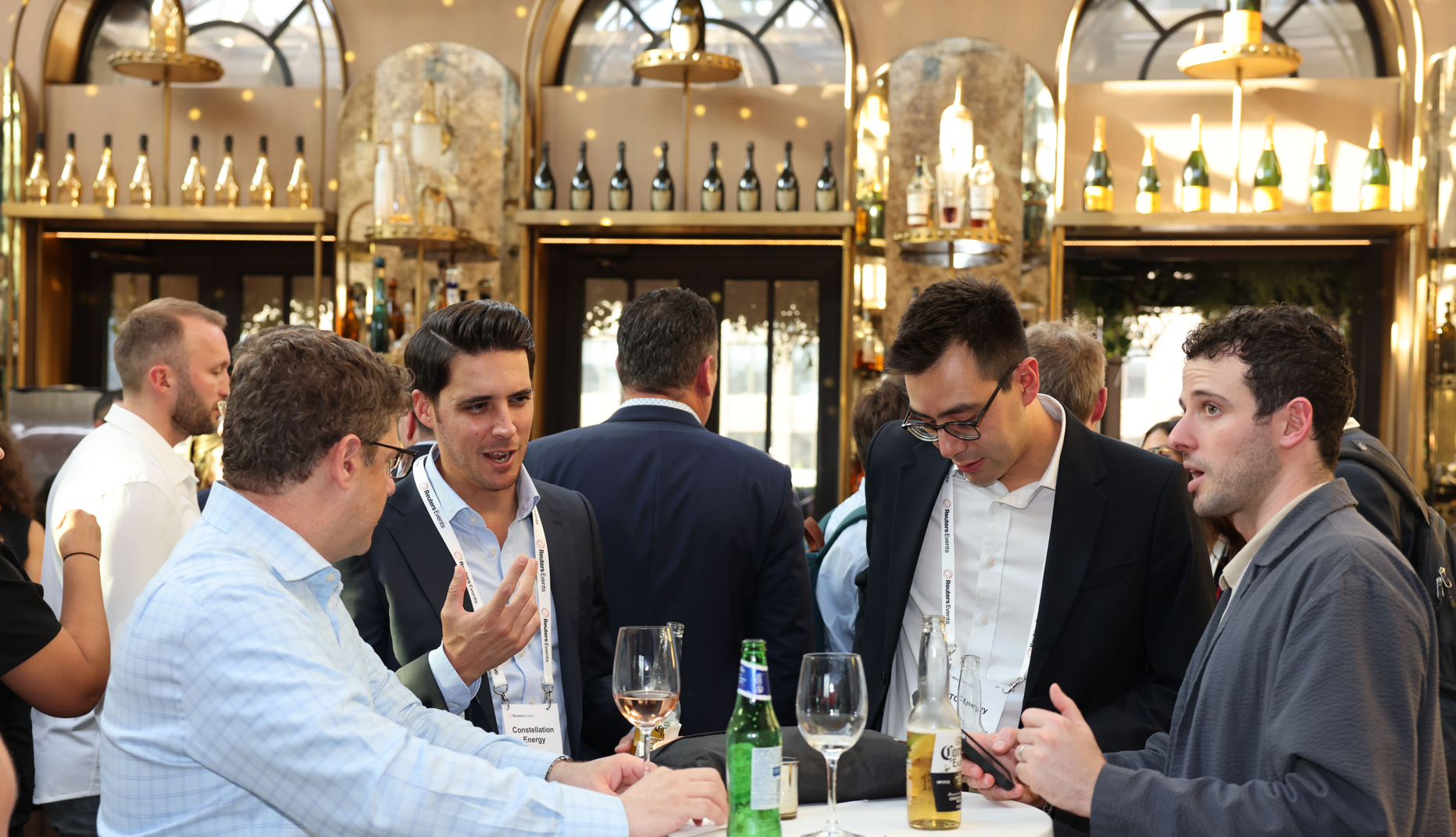Attendees network over drinks in an ornate bar.