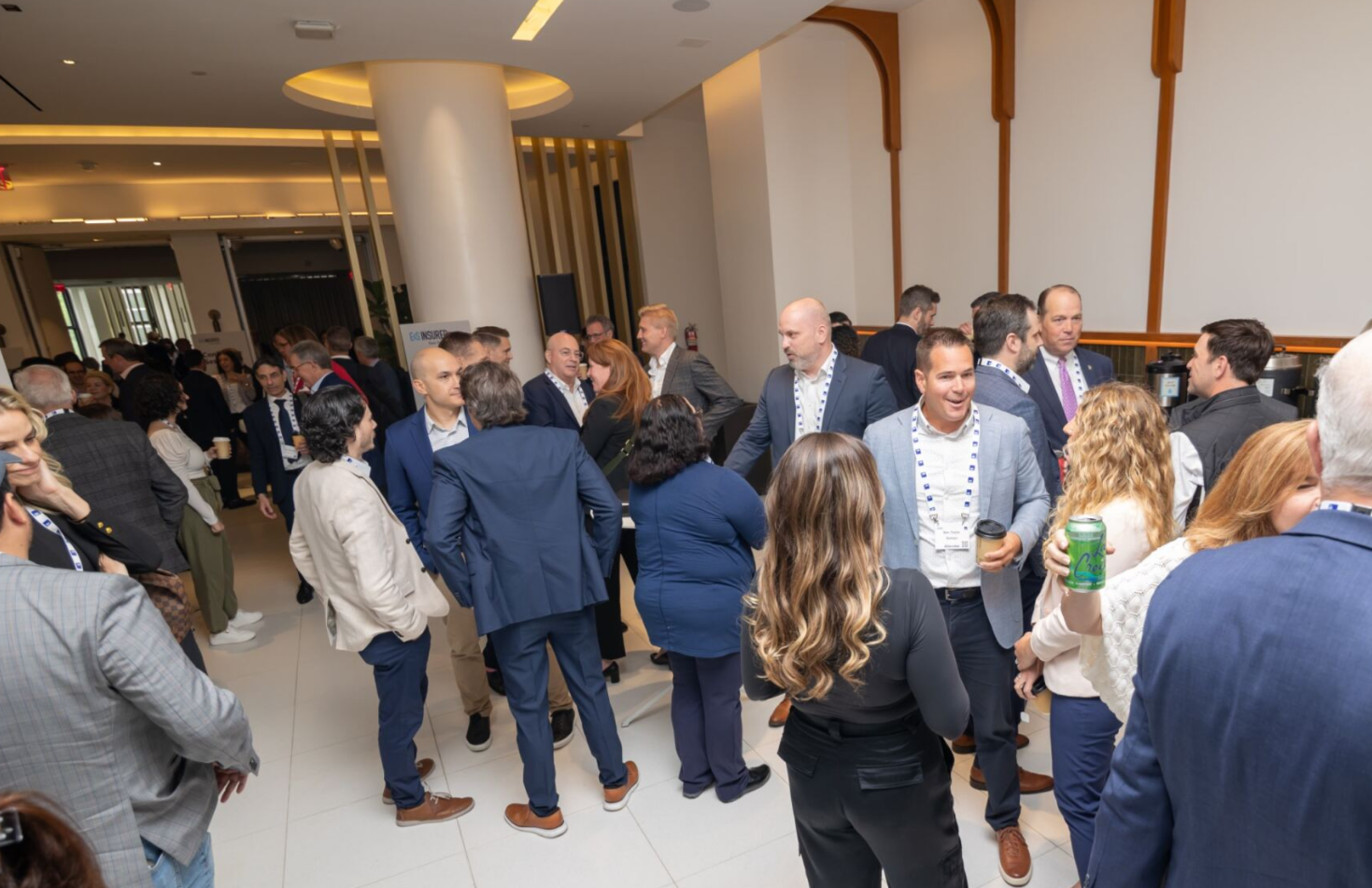 Conference attendees networking in a lobby area.
