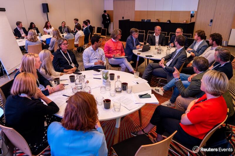 A photo of the a ground round table discsuion at a Transform Food & Agriculture event of people listening to a presentation 