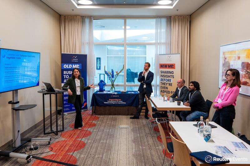 A room with 5 people looking at a presentation by one of our exhibitors at an event. 