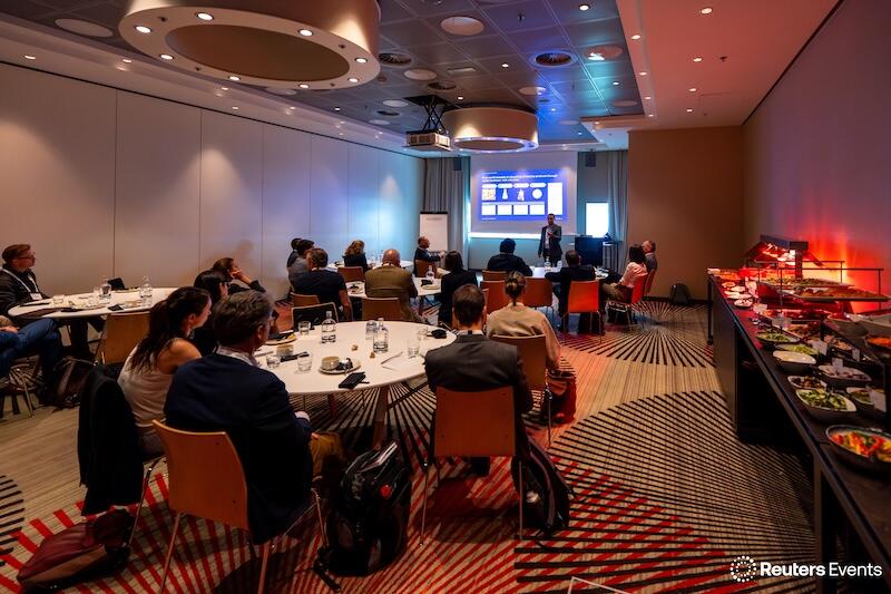 A photo of the a ground round table discsuion at a Transform Food & Agriculture event of people listening to a presentation on stage