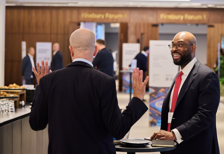 Two attendees networking during a break at the Momentum AI London conference.