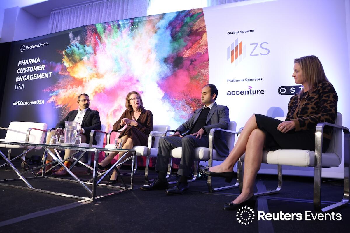 Photo of a stage with 4 speakers at Pharma Customer Engagement USA