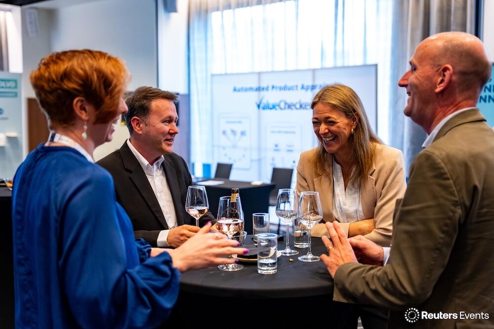 A photo fo 4 people having drinks and networking at the The Future of Insurance USA event