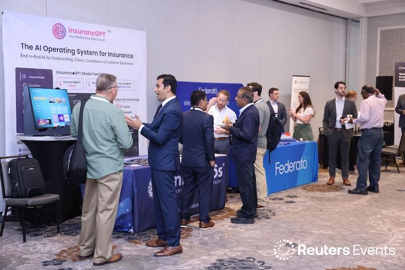 Busy expo hall with attendees networking and chatting around sponsor booths during an interactive break.