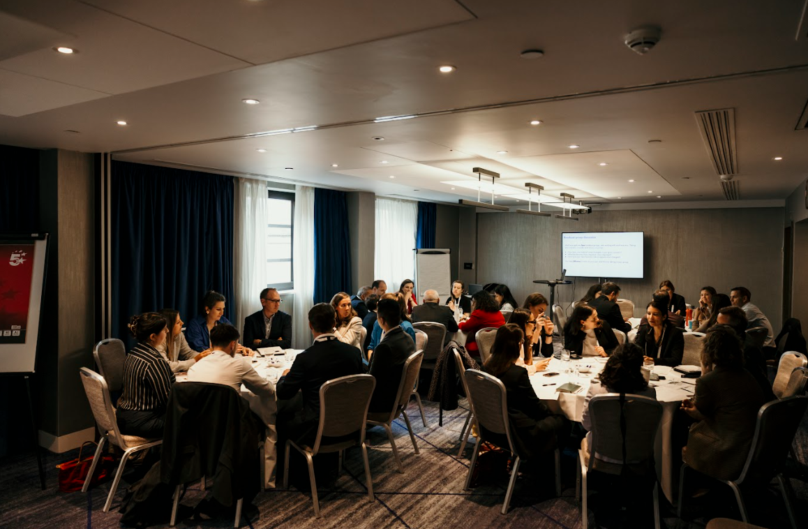 Conference workshop with multiple roundtables of attendees