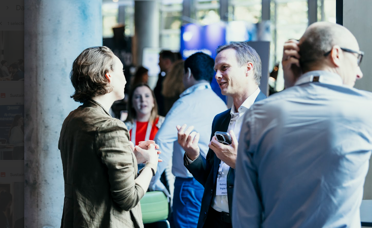 People networking and talking in a conference hallway.