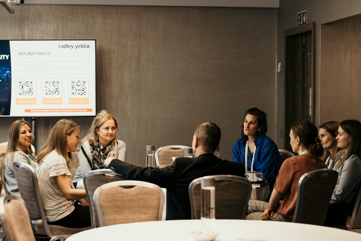 Roundtable discussion with attendees seated in a conference room