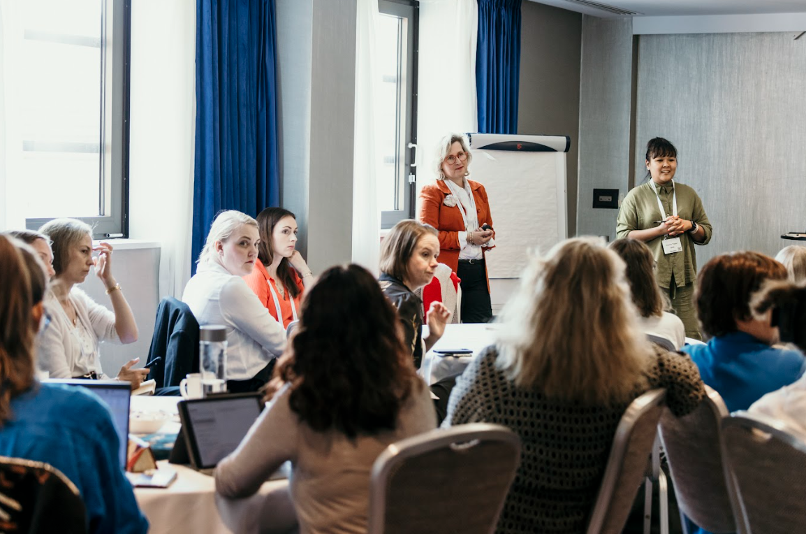 Facilitators presenting to attendees seated in a conference room