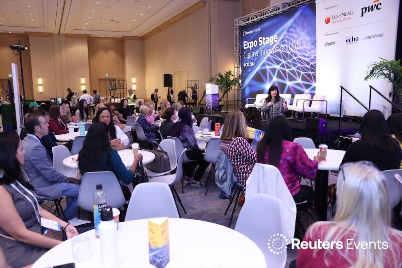 Speaker presenting on stage with “Strategic Marketing” backdrop, engaging the audience with a hands‑on talk