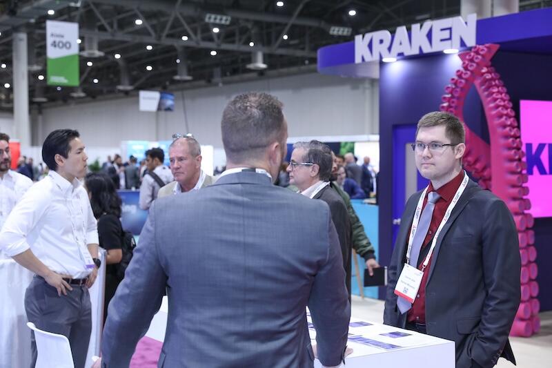 A group of people talking to exhibitors. 