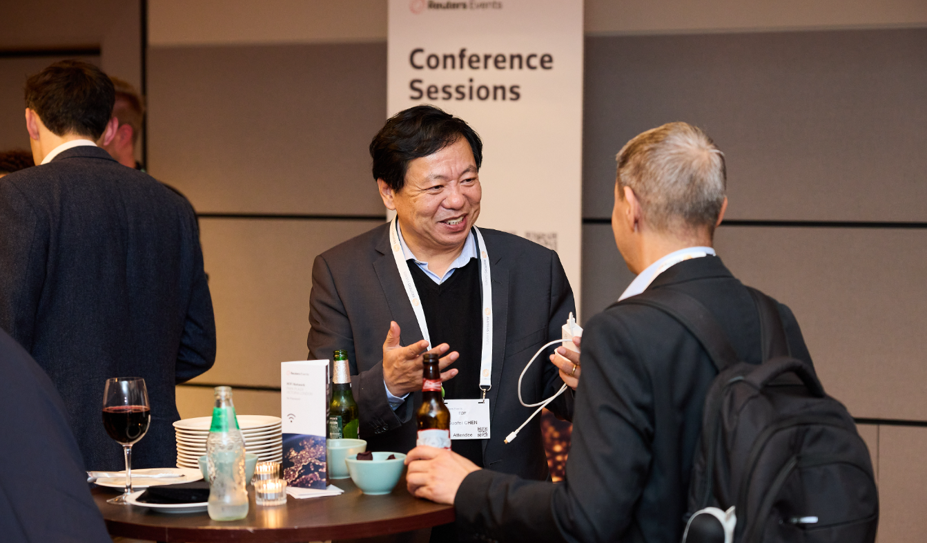 2 attendees networking over coffee outside the conference hall