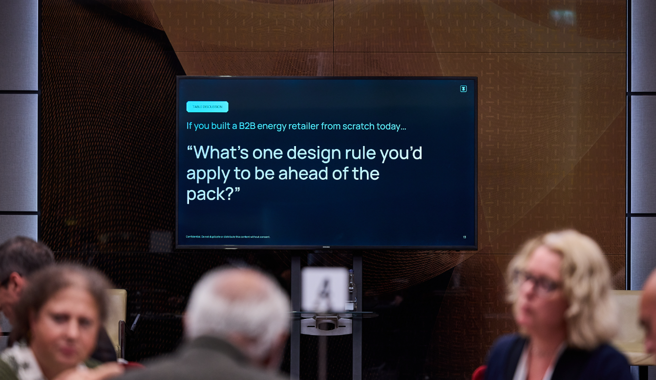 Presentation slide reading, "What's one design rule you'd apply to be ahead of the pack?" during a conference table discussion.