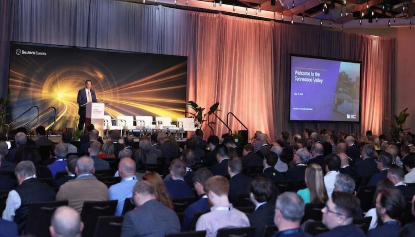 Keynote speaker addresses a full audience at the SMR & Advanced Reactor conference, with stage branding and slide visible.