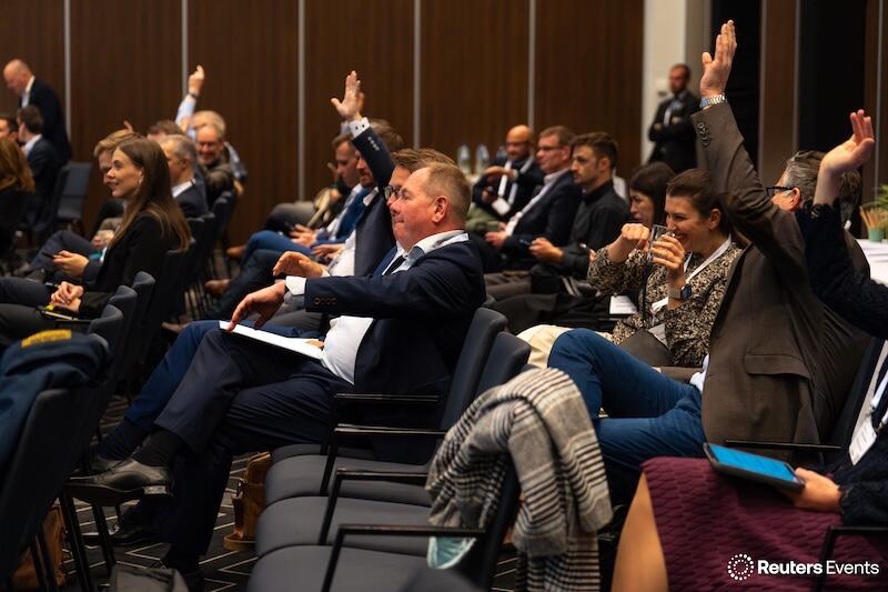 People in a room raising their hands
