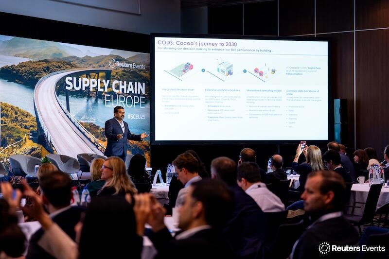 A presentation with a speaker on stage, showing a room full of people at Supply Chain Europe 2025