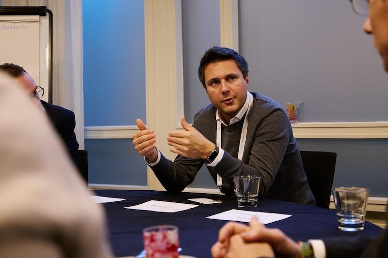 A photo of a person at a roundtable talking.