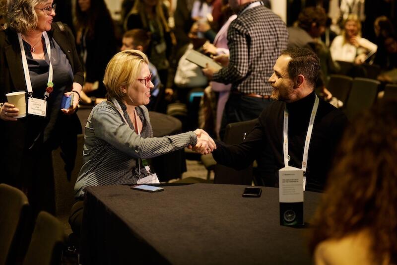 Two people shaking hands at a networking event